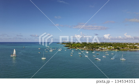 Scenic lagoon of Grand Baie Mauritius sailing boats near palm lined shore with Coin de Mire horizon 134534351