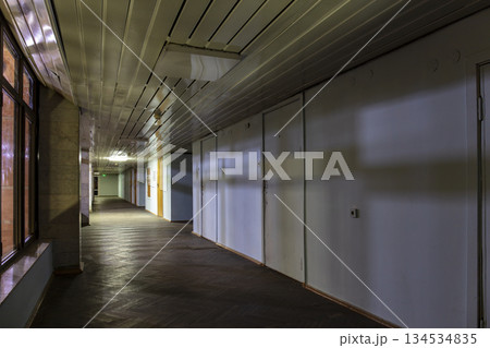 Long dark corridor in an old industrial building Long dark corridor in an old industrial building 134534835
