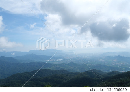 Vietnam Danang Misty mountains and lush forest view from Ba Na Hills near Da Nang Vietnam panoramic scenic landscape with clouds fog and tropical greenery. Vietnam Danang Misty mountains and lush forest view from Ba Na Hills near Da Nang Vietnam panoramic scenic landscape with clouds fog and tropical greenery. 134536020