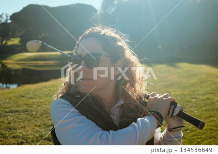 woman playing golf in the green fairway club woman playing golf in the green fairway club 134536649