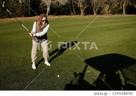 woman playing golf in the green fairway club woman playing golf in the green fairway club 134536650