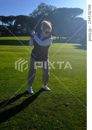 woman playing golf in the green fairway club 134536706