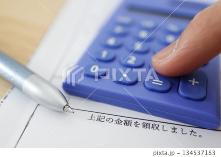 領収書と青い電卓の徴収済みイメージ。 134537183