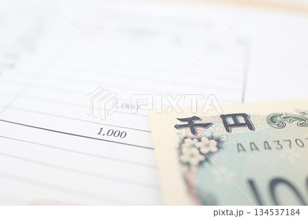 千円札と金額の記載書類で示す支払いイメージ。 千円札と金額の記載書類で示す支払いイメージ。 134537184