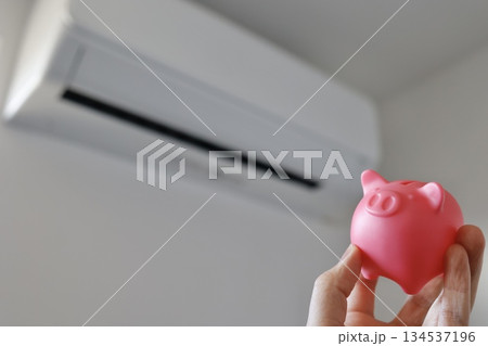 エアコンと豚の貯金箱を使った節電や電気代節約のイメージ。 エアコンと豚の貯金箱を使った節電や電気代節約のイメージ。 134537196