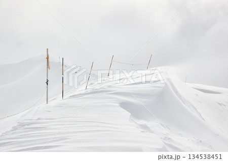 Winter high mountains in clouds 134538451