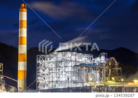 工場夜景を背景にした工場の煙突 134539287