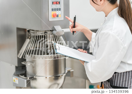 厨房機器を点検,チェックする厨房スタッフの女性 厨房機器を点検,チェックする厨房スタッフの女性 134539396