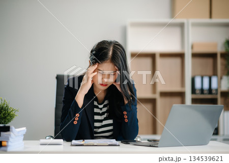 Asian business woman is stressed, bored, and overthinking from working on a tablet Asian business woman is stressed, bored, and overthinking from working on a tablet 134539621