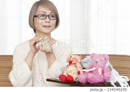 リビングでぬい活をするシニア女性 リビングでぬい活をするシニア女性 134540299