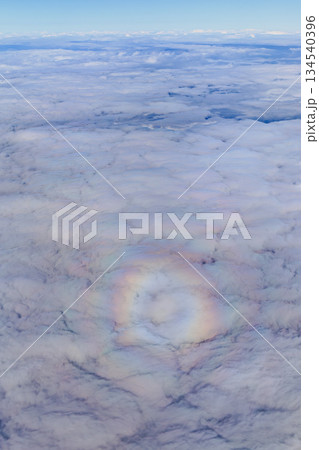 上空に広がる雲の海と淡く輝く光の輪 134540396