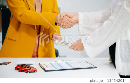 Asian people car salesman or sales manager offers to sell a car and explains of signing a car contract and signing car insurance 134542014