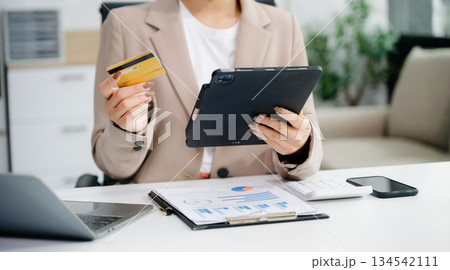businesswoman hand using smart phone, tablet payments and holding credit card online shopping, omni channel, digital tablet 134542111