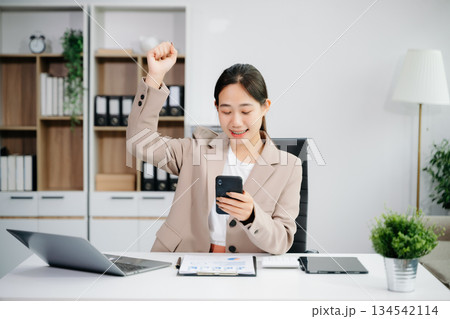 Asian business woman are delighted and happy with the work they do on their tablet, laptop and taking notes Asian business woman are delighted and happy with the work they do on their tablet, laptop and taking notes 134542114