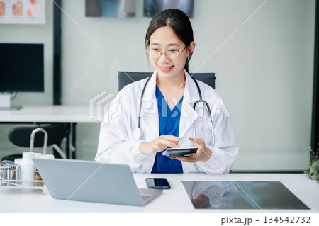 Healthcare costs and fees concept.Hand of smart doctor used a calculator and smartphone, tablet for medical costs at hospital Healthcare costs and fees concept.Hand of smart doctor used a calculator and smartphone, tablet for medical costs at hospital 134542732