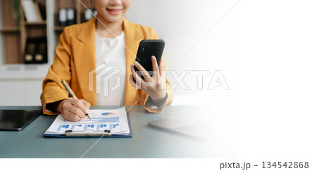 Businesswoman hand using laptop, tablet and smartphone in office. Digital marketing media mobile app and discussing plan new start up project. 134542868