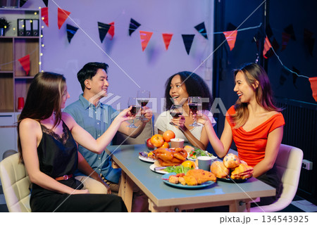 Celebration with friends enjoying food, drinks, and laughter at a lively house party. Perfect for themes of joy, togetherness, Celebration with friends enjoying food, drinks, and laughter at a lively house party. Perfect for themes of joy, togetherness, 134543925