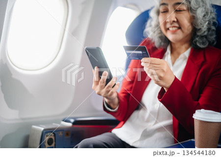 Asian seniorexecutive excels in first class, multitasking with digital tablet, laptop and smartphone. Travel in style, Asian seniorexecutive excels in first class, multitasking with digital tablet, laptop and smartphone. Travel in style, 134544180