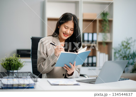 Beautiful Asian businesswoman typing laptop and tablet Placed at the table at the office 134544637