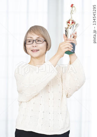 トロフィーを持つ元気なシニア女性 トロフィーを持つ元気なシニア女性 134545295