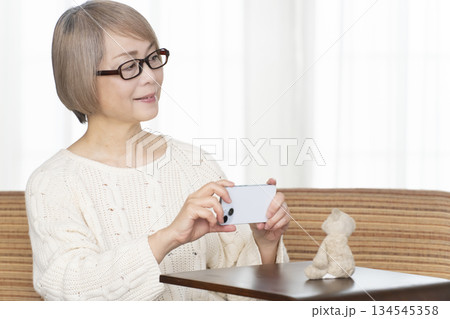リビングでぬい活をするシニア女性 134545358