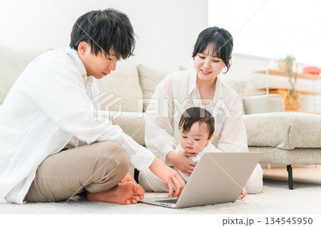 マイホームのリビングで子供,赤ちゃんと遊ぶ父親と母親（パソコン,育児,子育て,スキンシップ） 134545950