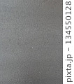 Dark wet asphalt pavement with a rough texture, viewed from above. Outdoor roadway background. Urban construction and road materials concept. Textured photo. 134550128
