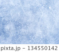 A background of blue ice with scratches and cracks. The frozen surface of a lake, a Christmas winter skating rink. A textured backdrop for New Year's, winter sports, and entertainment. 134550142
