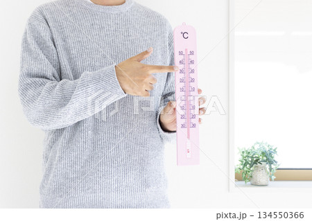 大きな温度計を持つ男性（日本人、顔無し、30代）_冬 134550366