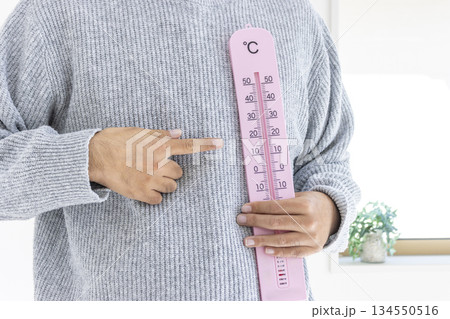 大きな温度計を持つ男性(日本人、顔無し、30代)_冬 大きな温度計を持つ男性(日本人、顔無し、30代)_冬 134550516