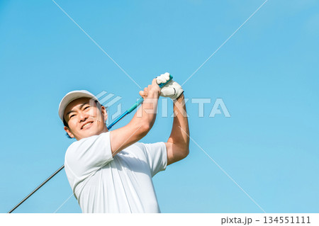 ゴルフ場でゴルフをするゴルファーの男性(笑顔・ティーショット・ゴルフコンペ) 134551111