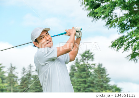 ゴルフ場でゴルフをするゴルファーの男性(笑顔・ティーショット・ゴルフコンペ) 134551115