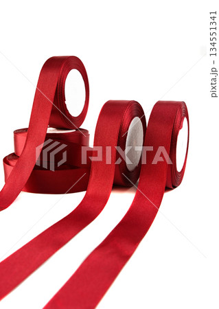 Set of satin red ribbons in rolls on a white background, showcasing vibrant color and smooth texture, ideal for crafting, sewing and decorative hobby projects. Set of satin red ribbons in rolls on a white background, showcasing vibrant color and smooth texture, ideal for crafting, sewing and decorative hobby projects. 134551341