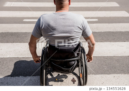 Handicapped man in wheelchair crossing street road 134551626
