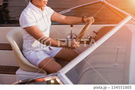 Young man on sailing yacht. Hands hold steering wheel 134551805