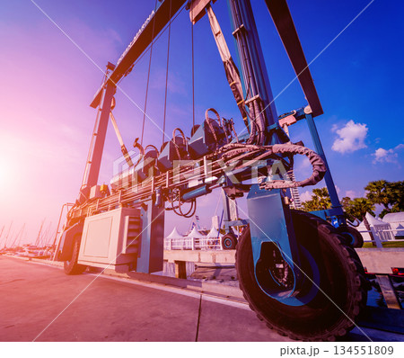 Lifting crane for elevating boat at harbor docks. 134551809