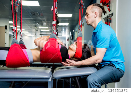 Physiotherapy. Suspension training therapy. Young woman doing fitness traction 134551872