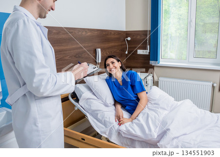 Traumatologist talking with young female patient in modern hospital 134551903