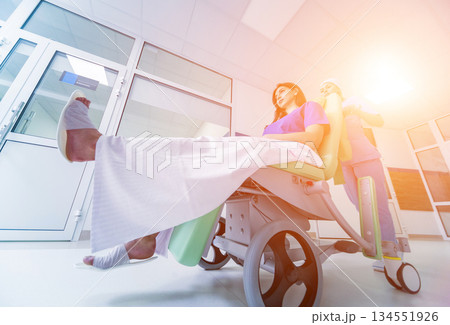 Nurse moves mobile medical chair with patient at hospital. Medical equipment. Nurse moves mobile medical chair with patient at hospital. Medical equipment. 134551926