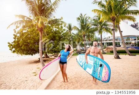 Two young surfers with boards on the beach Two young surfers with boards on the beach 134551956