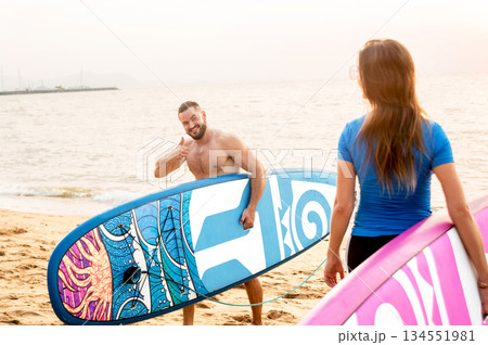 Two young surfers going into the sea with surf boards Two young surfers going into the sea with surf boards 134551981