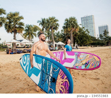 Two young surfers going into the sea with surf boards Two young surfers going into the sea with surf boards 134551983