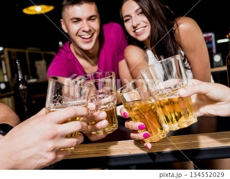 Cheerful friends in the pub. Drinking beer, talking, having fun. Cheerful friends in the pub. Drinking beer, talking, having fun. 134552029