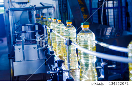 Bottling line of sunflower oil in bottles. Vegetable oil production plant. Bottling line of sunflower oil in bottles. Vegetable oil production plant. 134552071
