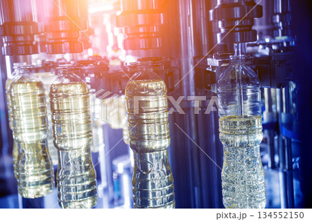 Bottling line of sunflower oil in bottles. Vegetable oil production plant Bottling line of sunflower oil in bottles. Vegetable oil production plant 134552150