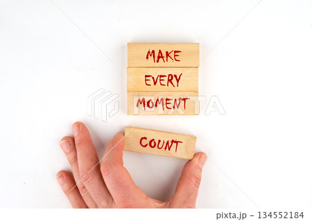 A hand places a wooden block that reads COUNT beneath stacked blocks reading MAKE EVERY MOMENT. The message promotes mindfulness and seizing opportunities A hand places a wooden block that reads COUNT beneath stacked blocks reading MAKE EVERY MOMENT. The message promotes mindfulness and seizing opportunities 134552184