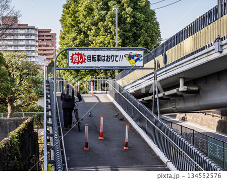 歩道橋での自転車の押し歩き（乗車禁止）を求める注意喚起看板 134552576