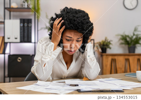 African American businesswoman stressed by bills debt and high taxes fears looming major bankruptcy 134553015
