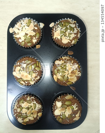 Healthy muffin tray seed baked muffin pumpkin seed almond slice sesame seed homemade snack breakfast food dessert nut topping 134554097