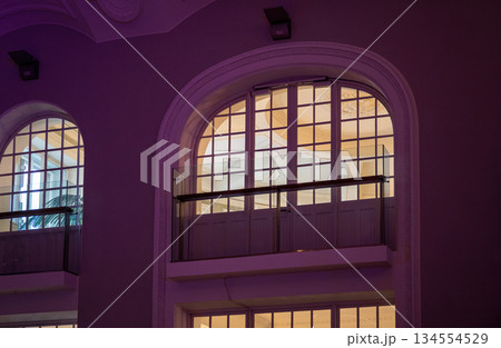 Elegant arched windows with purple ambient lighting in classic interior Elegant arched windows with purple ambient lighting in classic interior 134554529